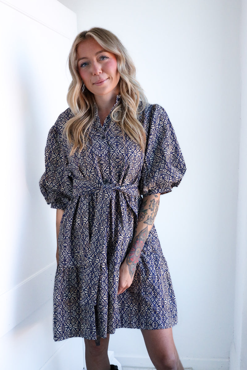 Woman wearing a patterned dress against a white background