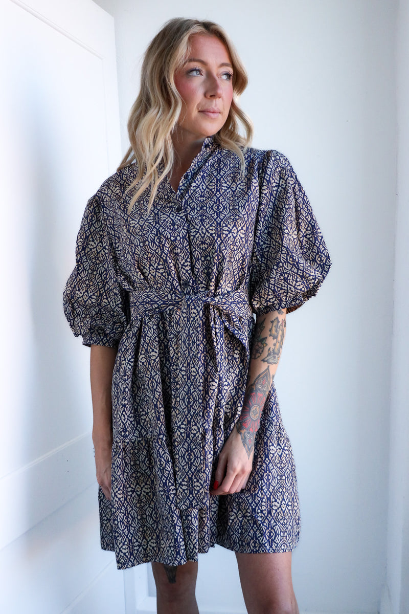 Woman wearing a patterned dress against a white background