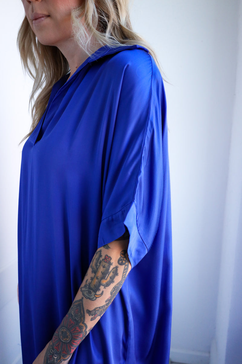 Person wearing a blue dress with a plain background