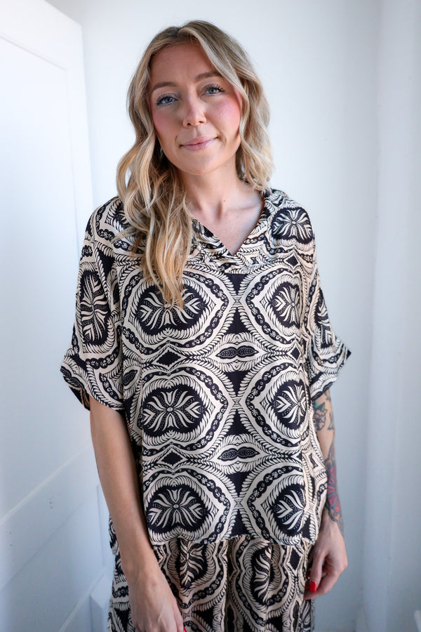 Woman wearing a black and white patterned dress against a white background