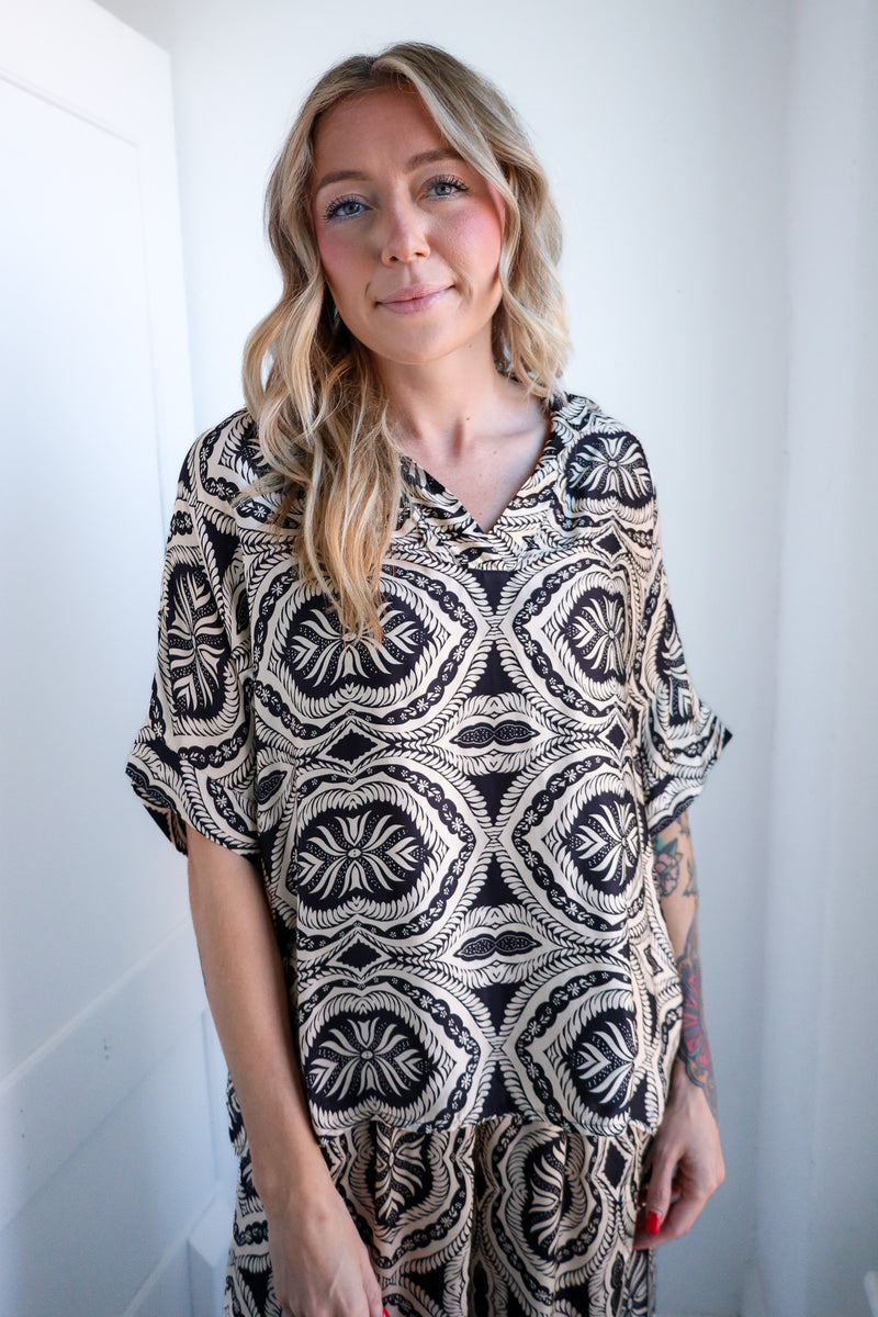 Woman wearing a black and white patterned dress against a white background