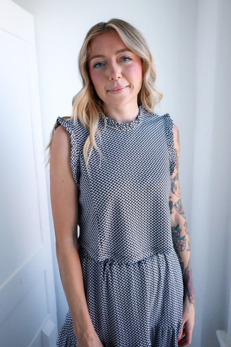 Woman wearing a patterned dress against a plain background