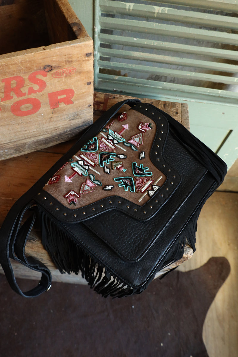 Experience the ultimate in boho-chic with the Old Gringo Mojo Black Bag. Made of luxurious black leather, this crossbody purse features a stunning tribal pattern beaded brown leather flap, embellished with studs and black fringe. A magnet closure, back zipper compartment, and multiple inside pockets make it both stylish and functional. Elevate your outfit with this statement piece!