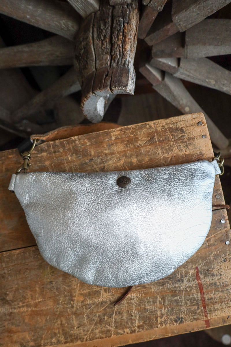 Silver leather pouch on a wooden surface with rustic background