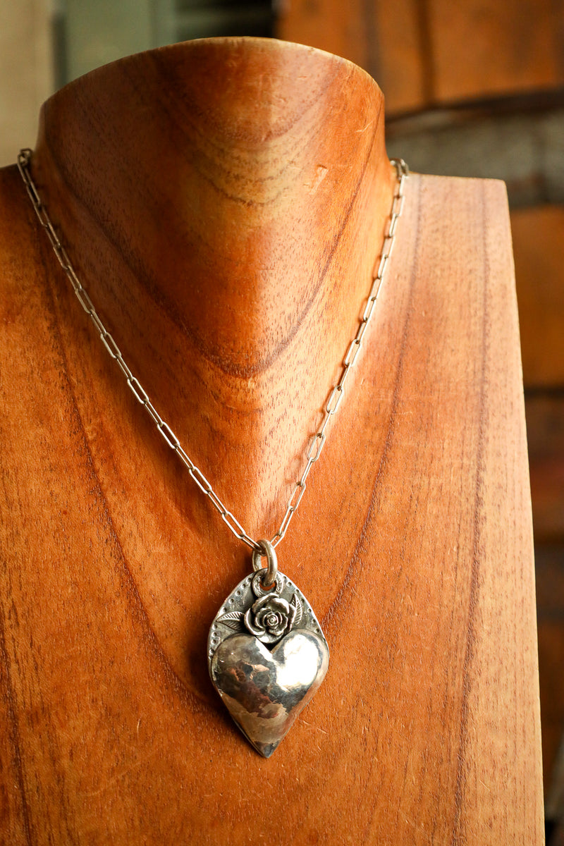 Silver pendant necklace on a wooden mannequin