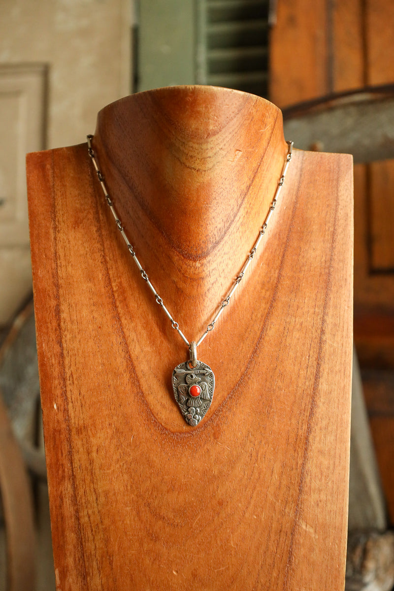 Necklace with a pendant on a wooden mannequin bust