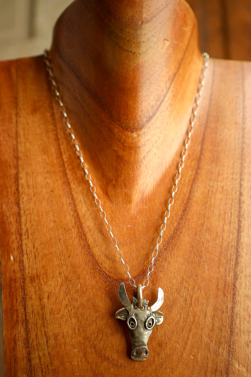 Necklace with a bull head pendant on a wooden mannequin