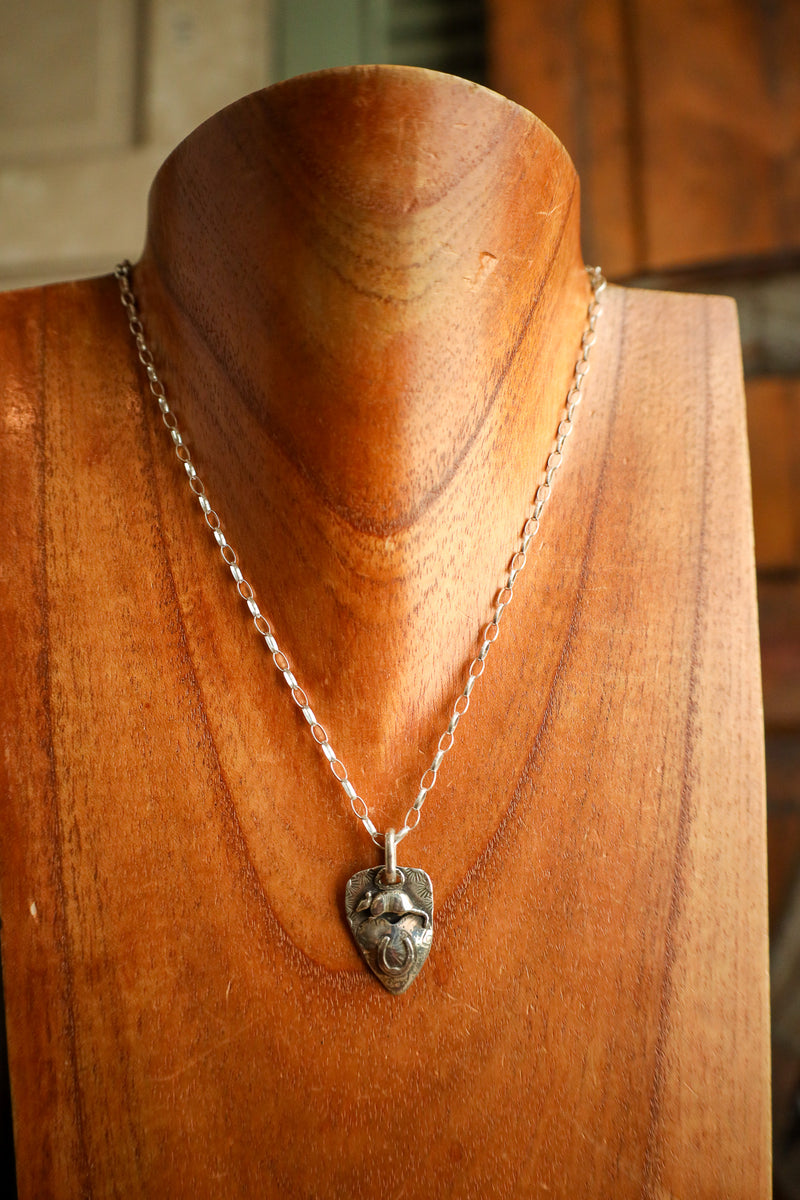 Silver necklace with a pendant on a wooden mannequin
