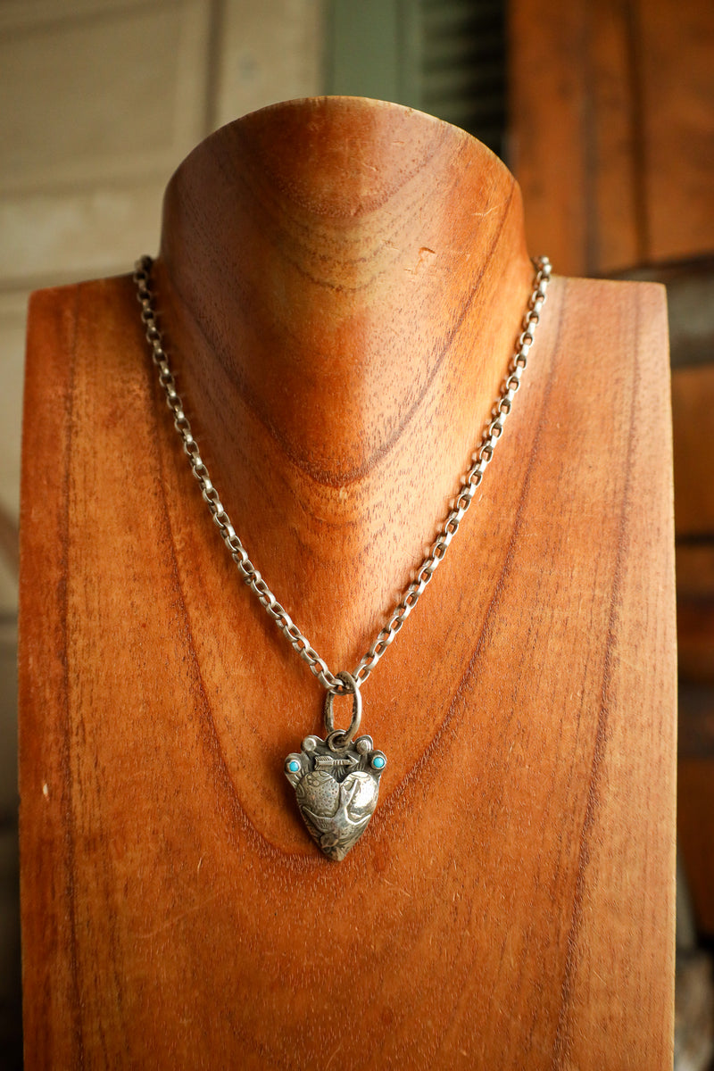 Necklace with a heart-shaped pendant on a wooden mannequin
