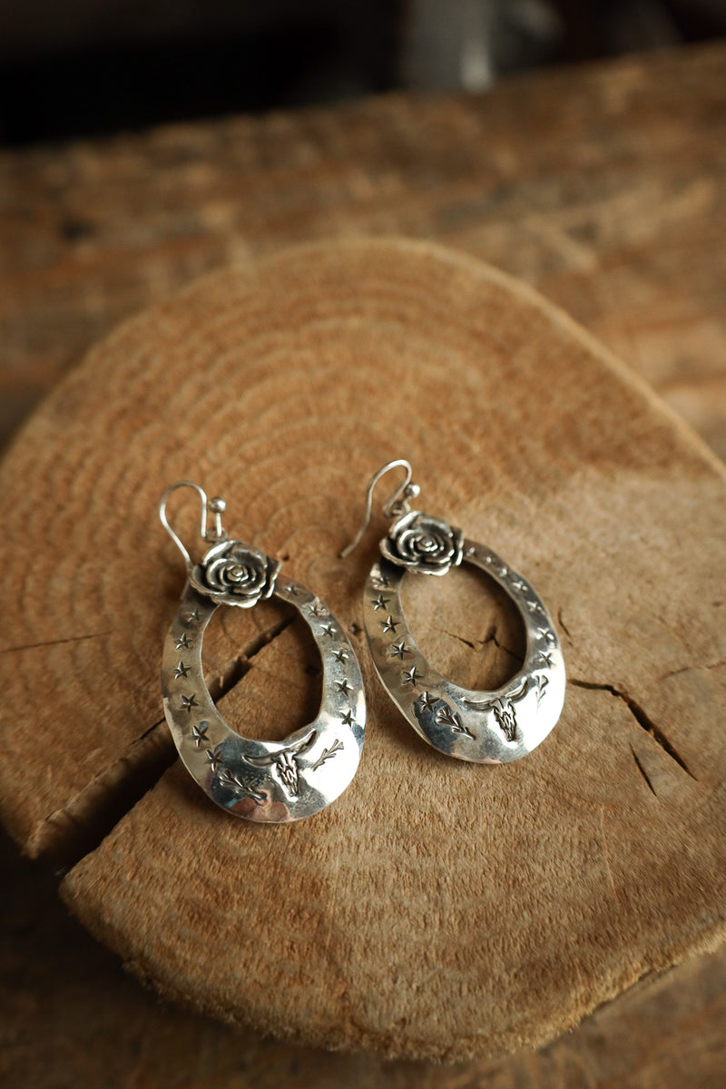 Silver hoop earrings on a wooden surface