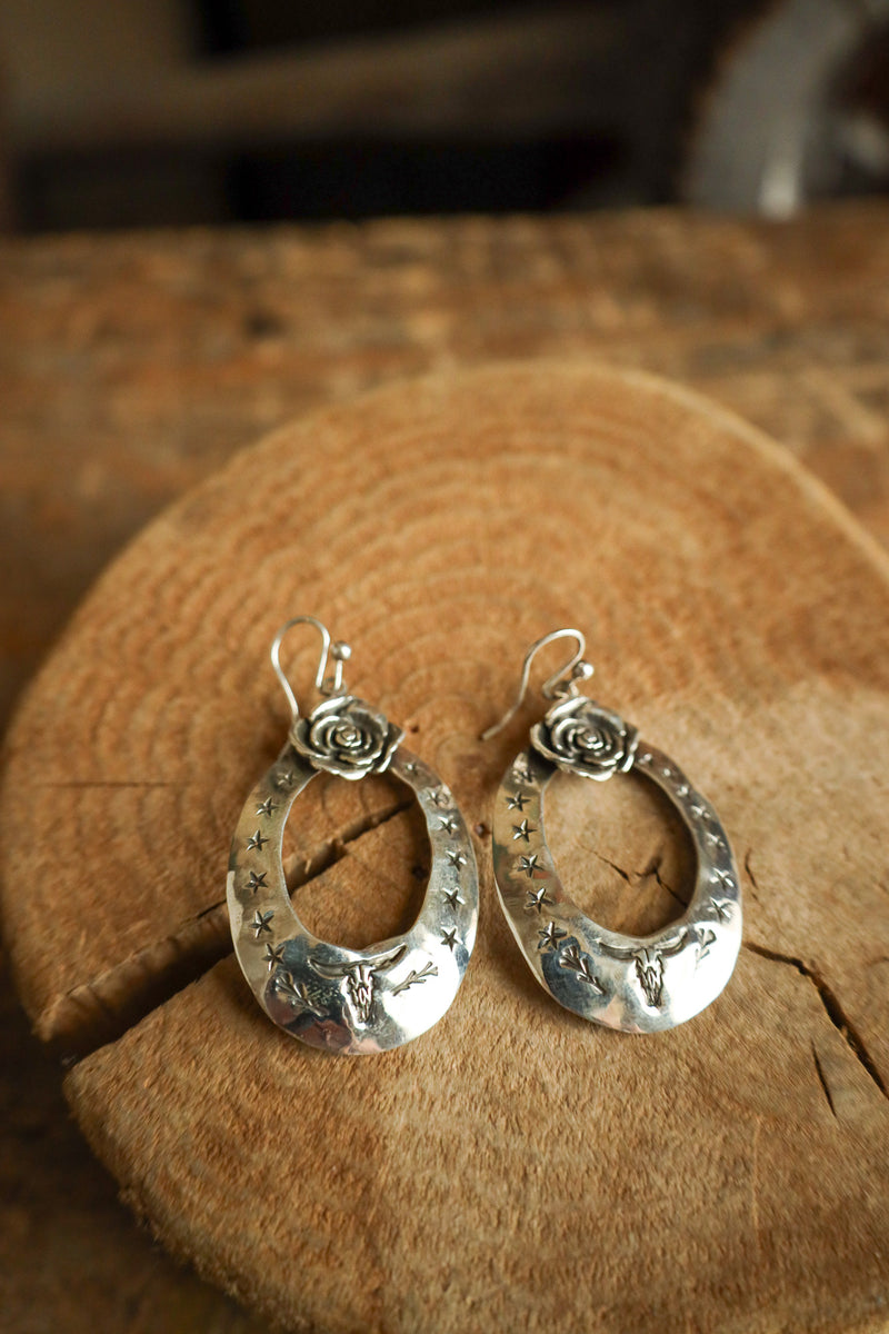 Silver hoop earrings on a wooden surface