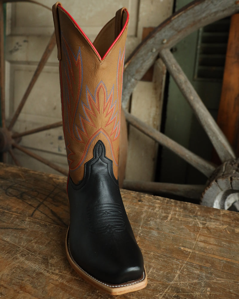 Cowboy boot with black sole on a wooden surface with a rustic background