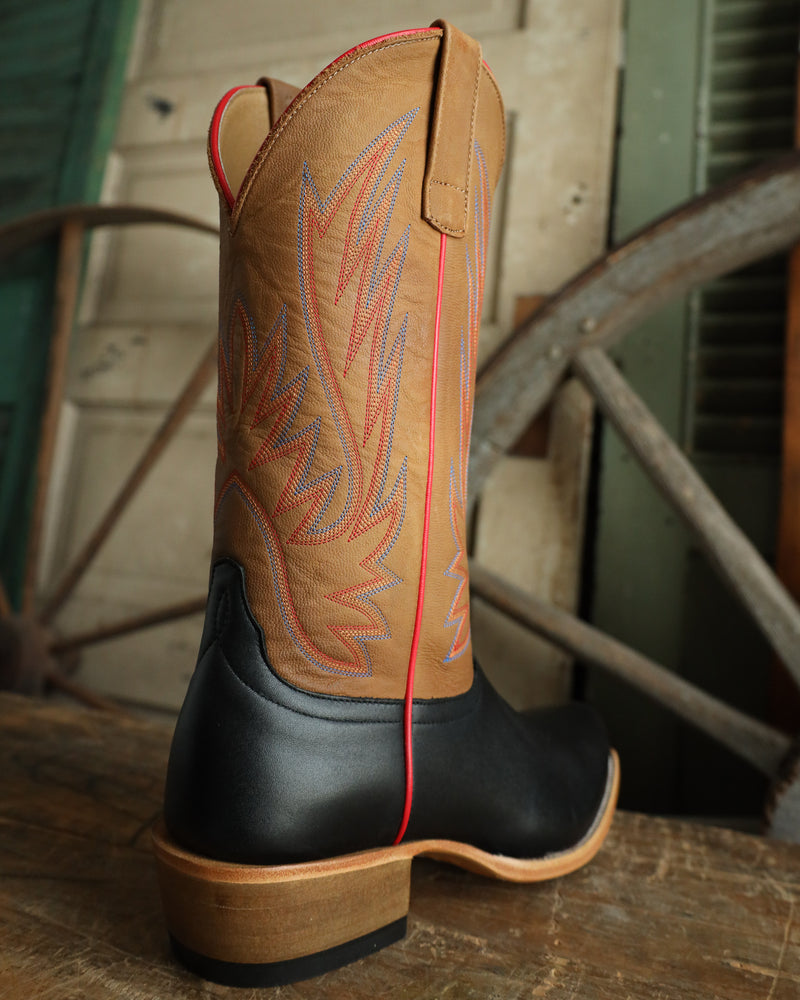 Cowboy boot with intricate design on a wooden surface