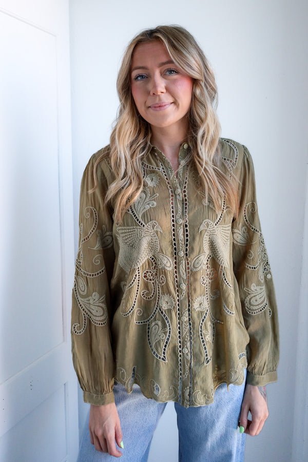 Woman wearing a patterned blouse against a white background