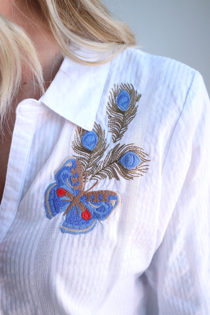White shirt with blue butterfly and peacock feather embroidery