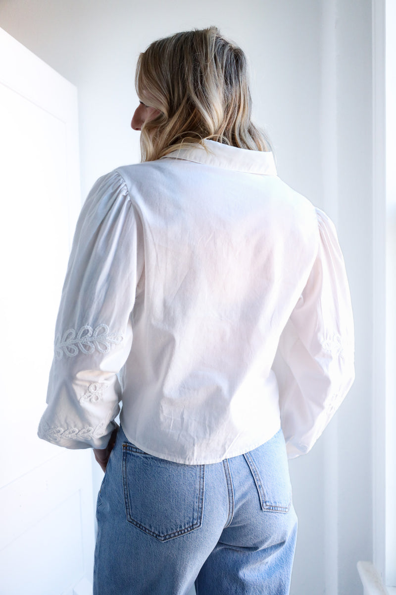 Person wearing a white shirt and blue jeans against a white background