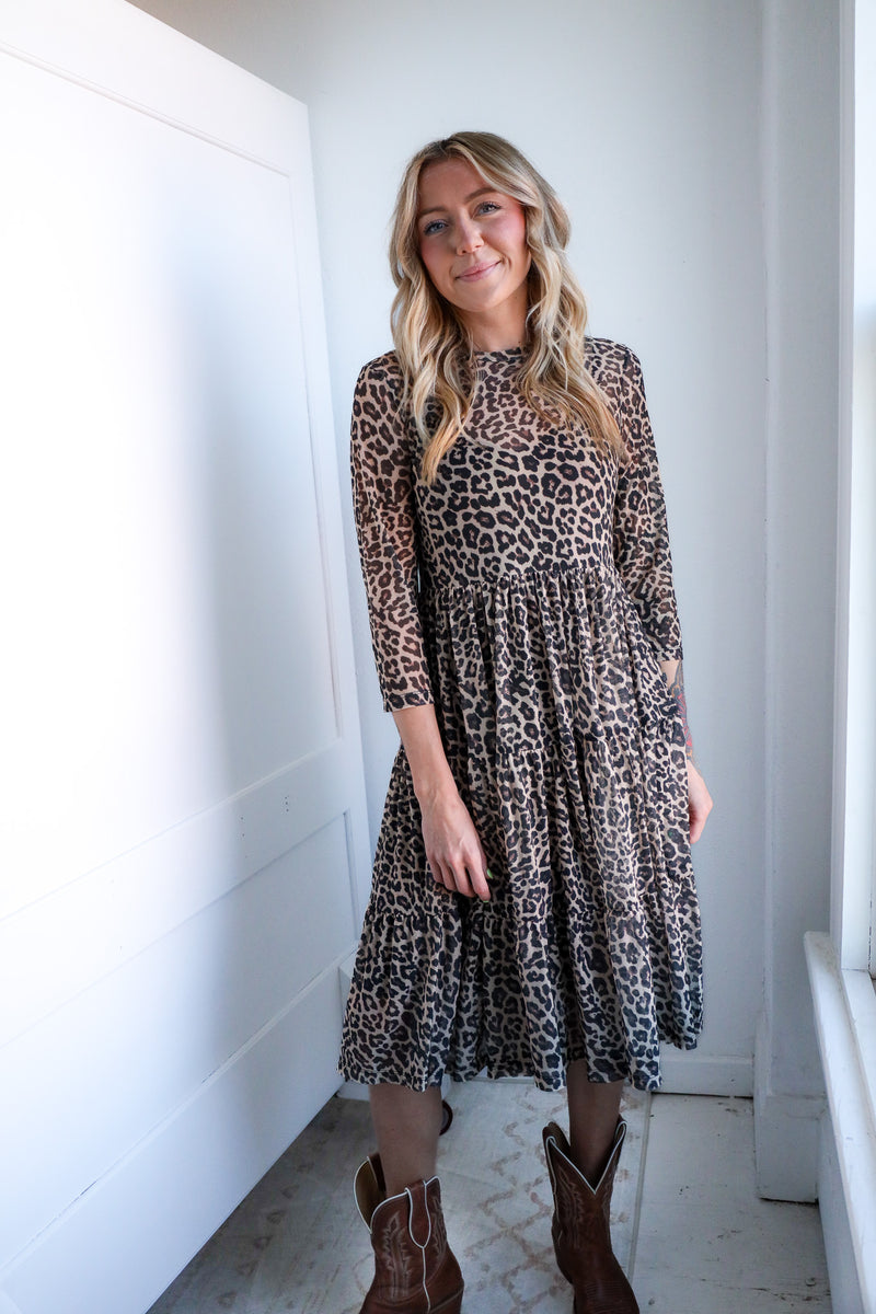 Woman wearing a leopard print dress in a bright room