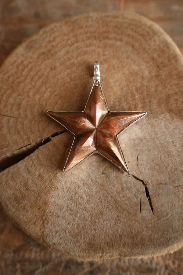 Copper star pendant on a wooden surface