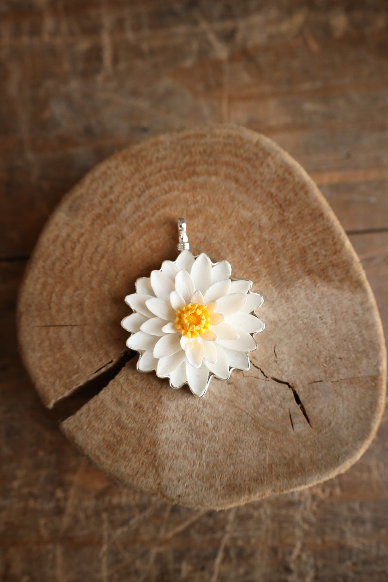 White flower pendant on a wooden surface