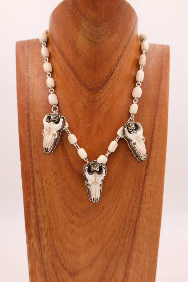 Three bone buffalo head charms with bone beads comprising the entire necklace