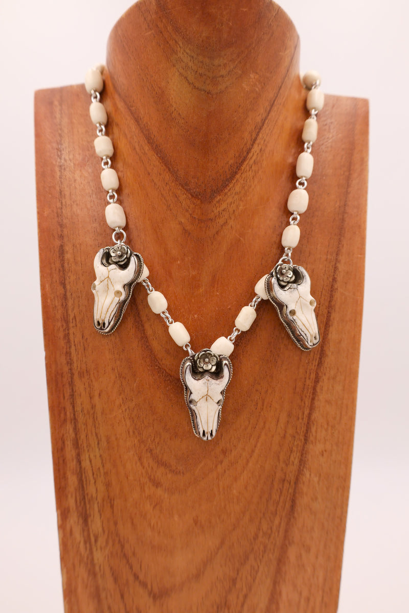 Three bone buffalo head charms with bone beads comprising the entire necklace