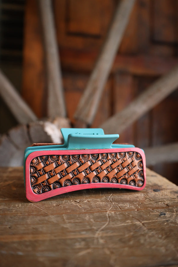 Colorful woven clutch bag on a wooden surface with a rustic background