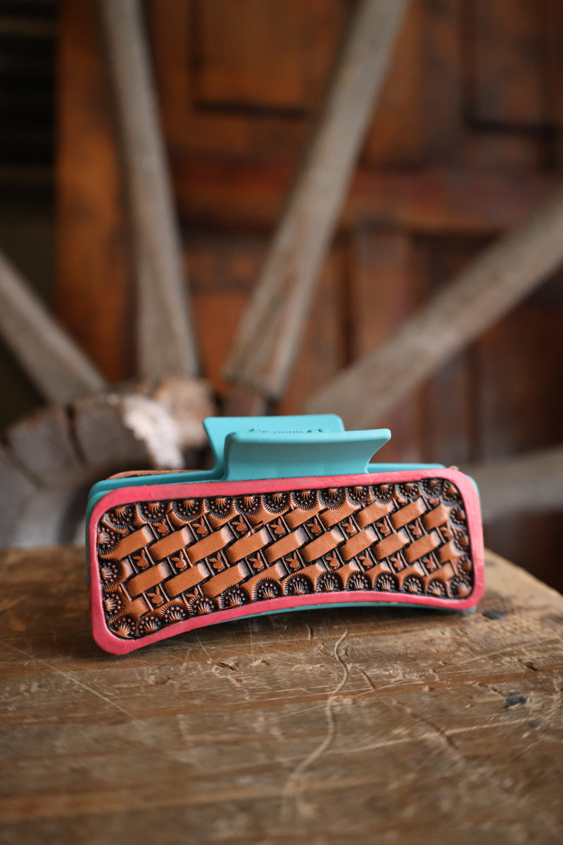 Phone case with woven design and pink border on a wooden surface