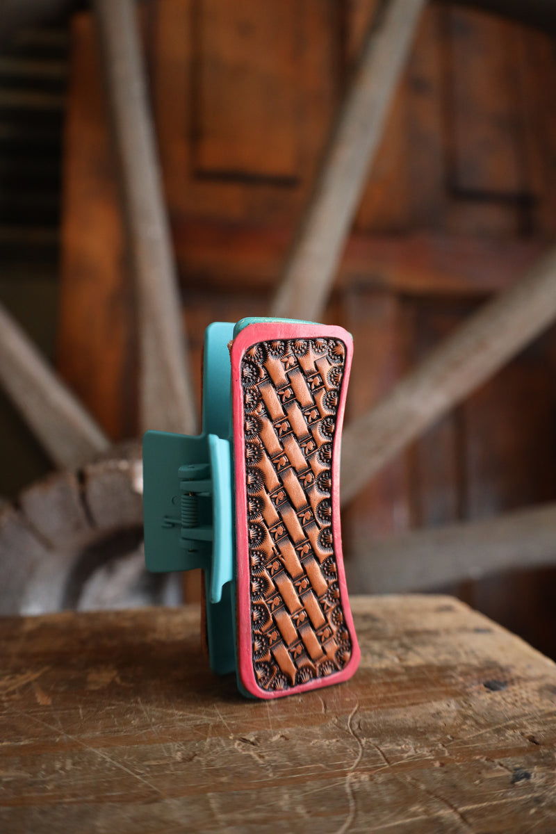 Wooden tool with pink and green accents on a wooden surface