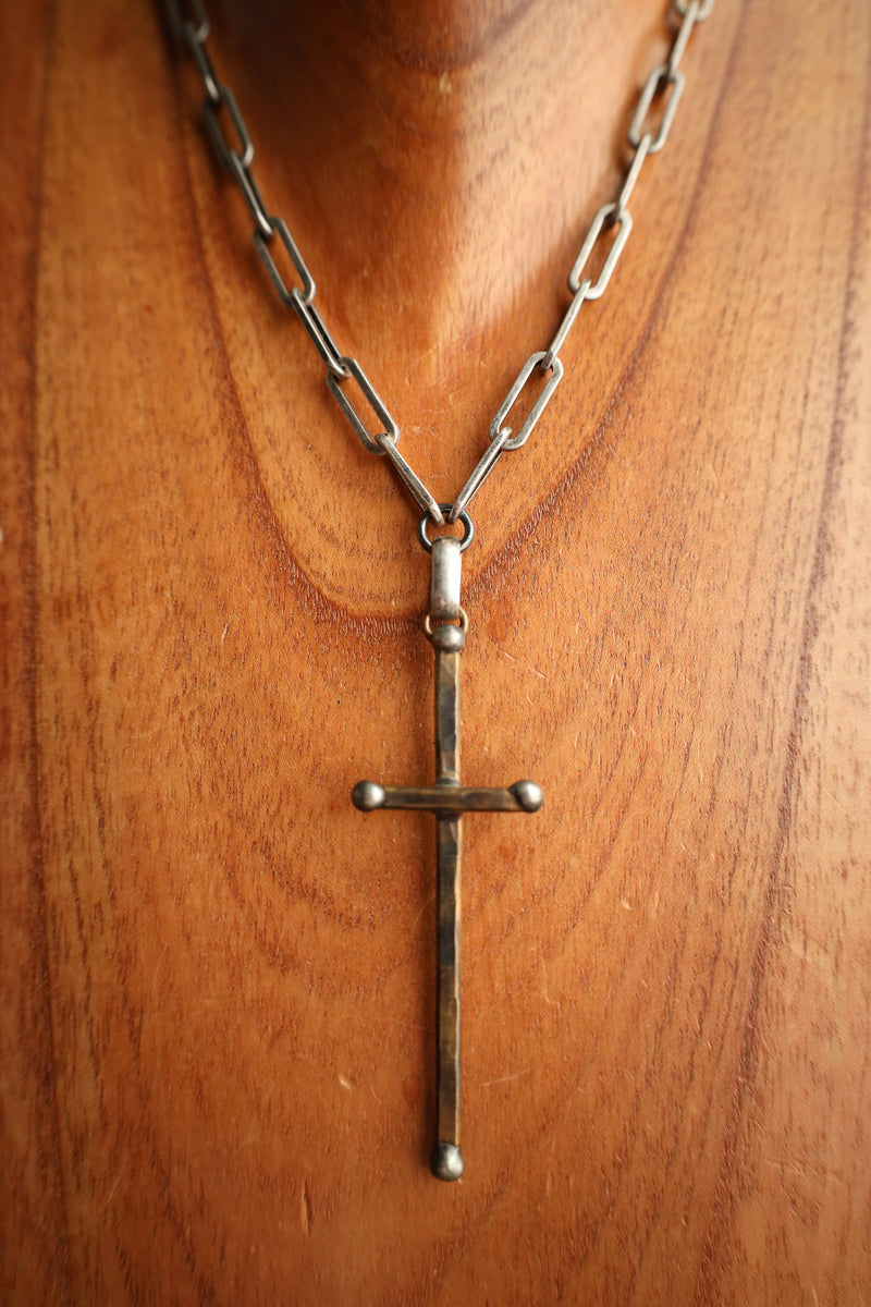 Silver cross necklace on a wooden surface