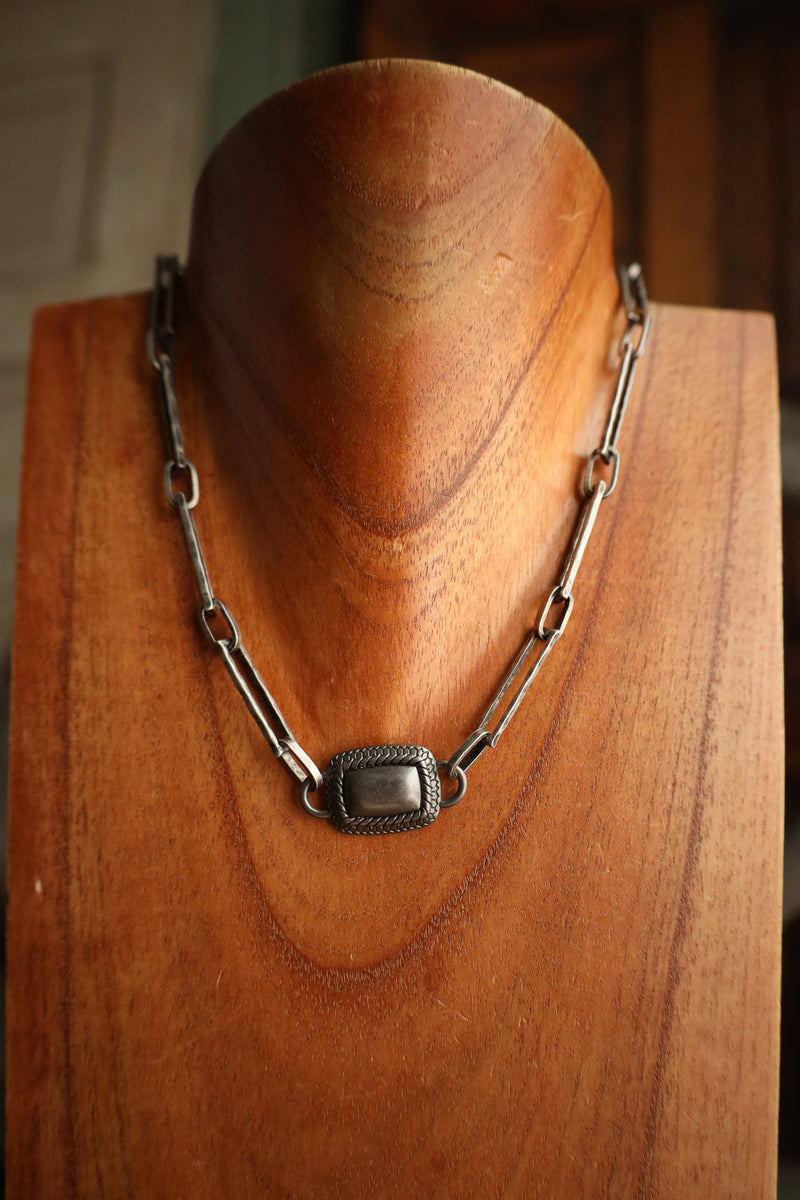 Silver chain necklace on a wooden mannequin head