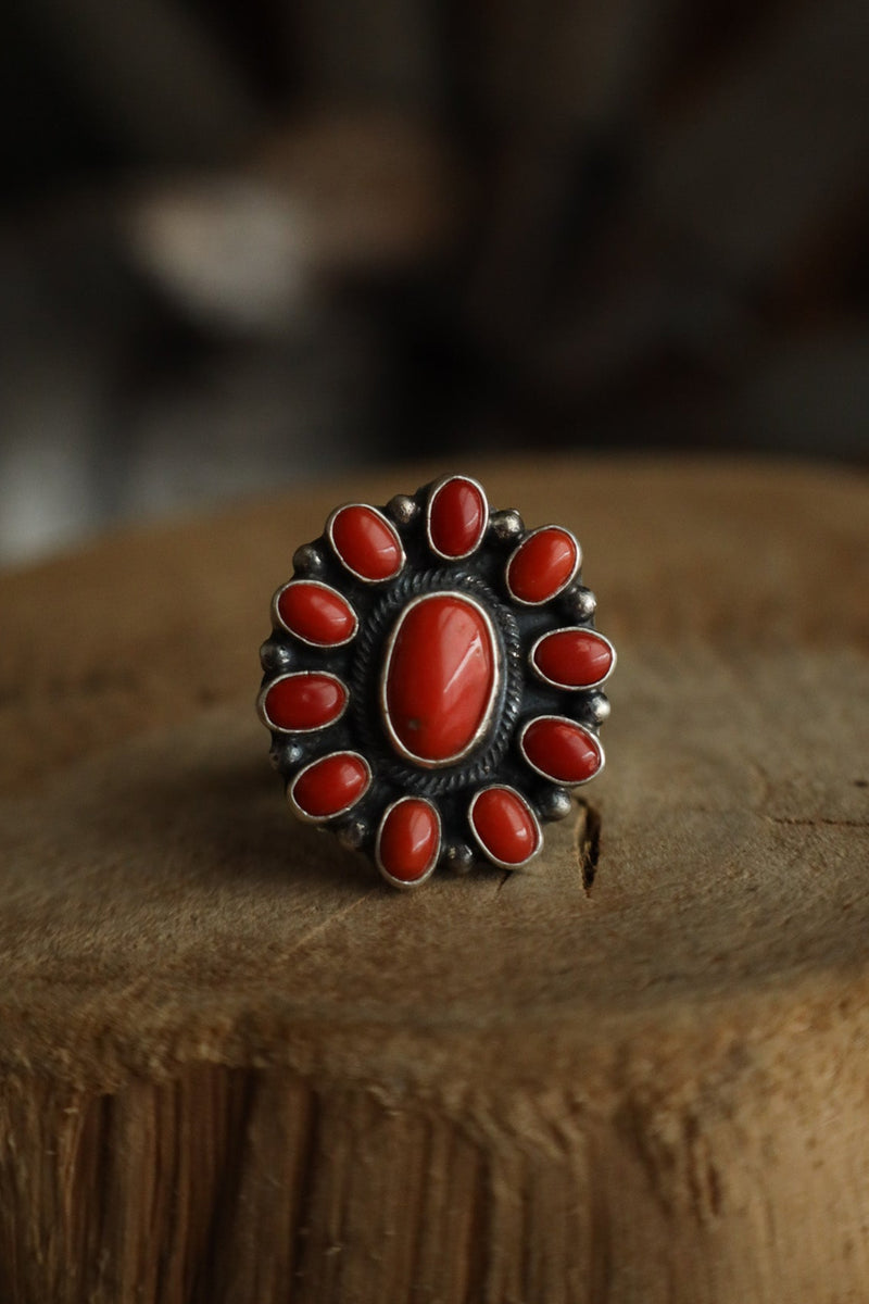 Ring with red stones on a wooden surface