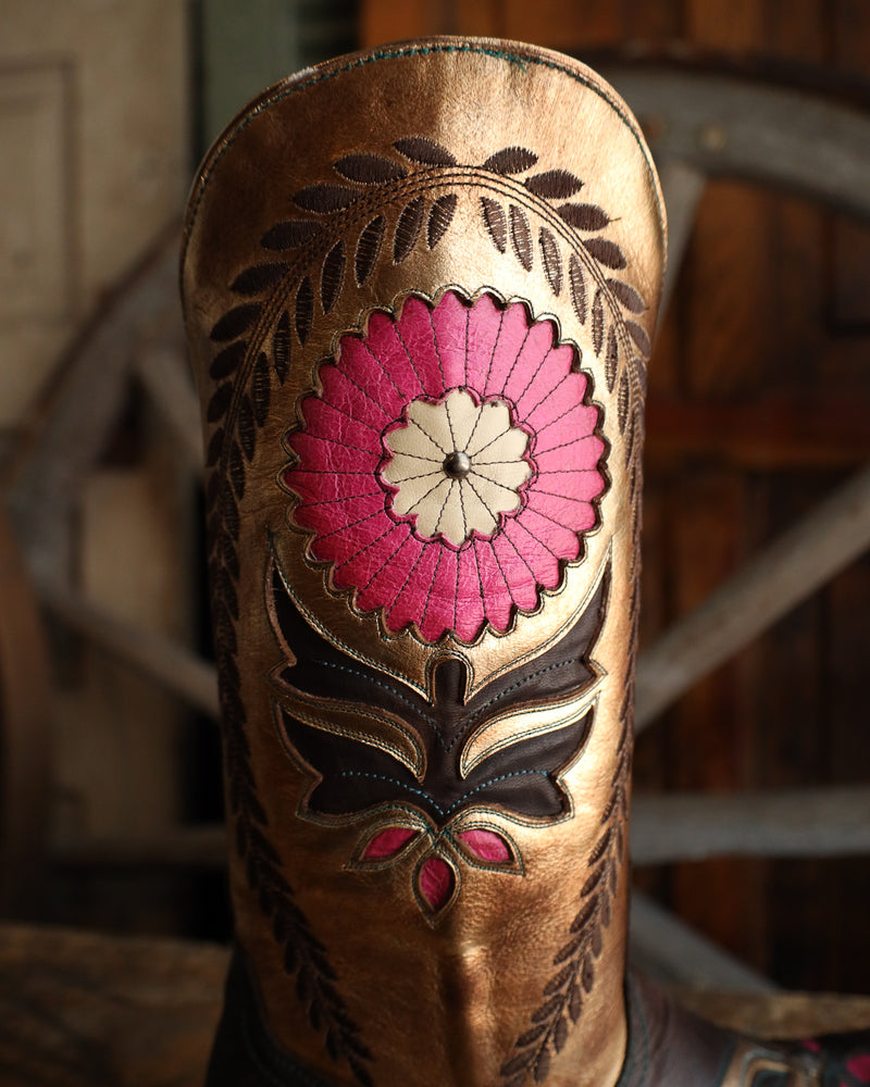 Close-up of a brown leather boot with floral embroidery in pink and black.