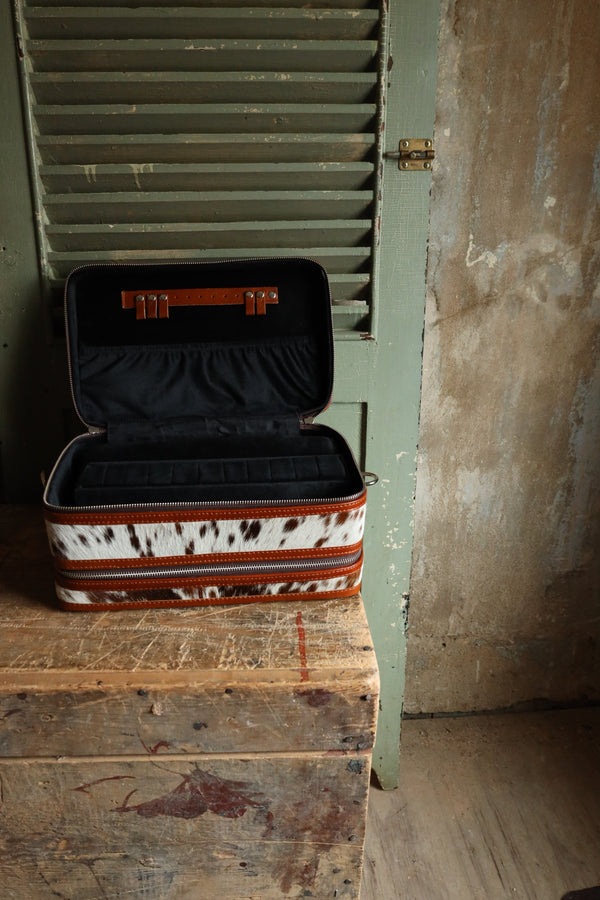 Double decker jewelry case with cowhide exterior and leather tooling and includes travel strap