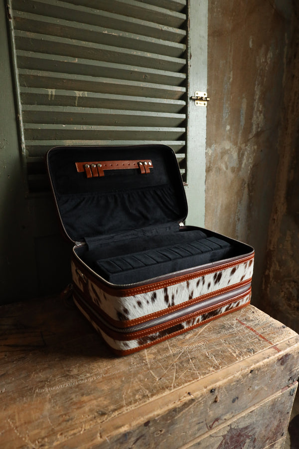 Double decker jewelry case with cowhide exterior and leather tooling and includes travel strap