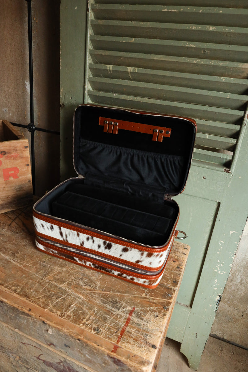 Double decker jewelry case with cowhide exterior and leather tooling and includes travel strap