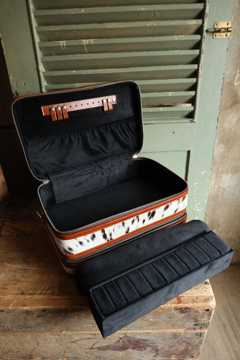 Double decker jewelry case with cowhide exterior and leather tooling and includes travel strap