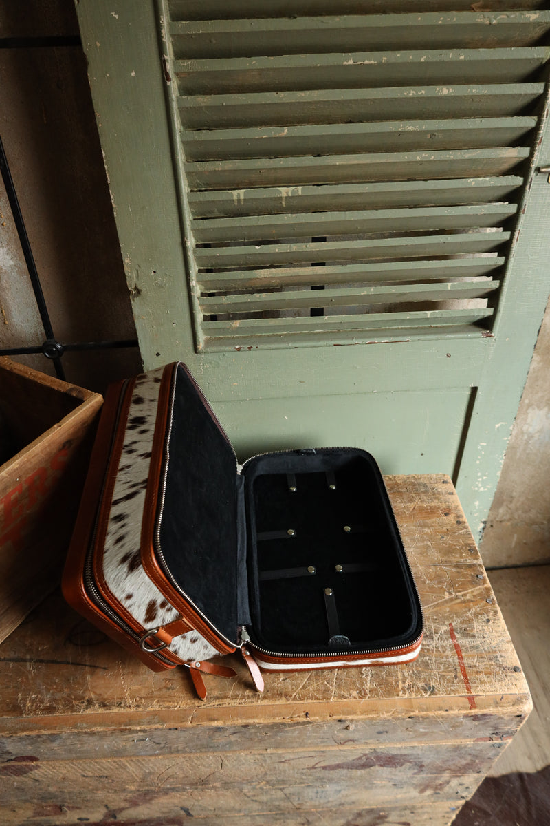 Double decker jewelry case with cowhide exterior and leather tooling and includes travel strap