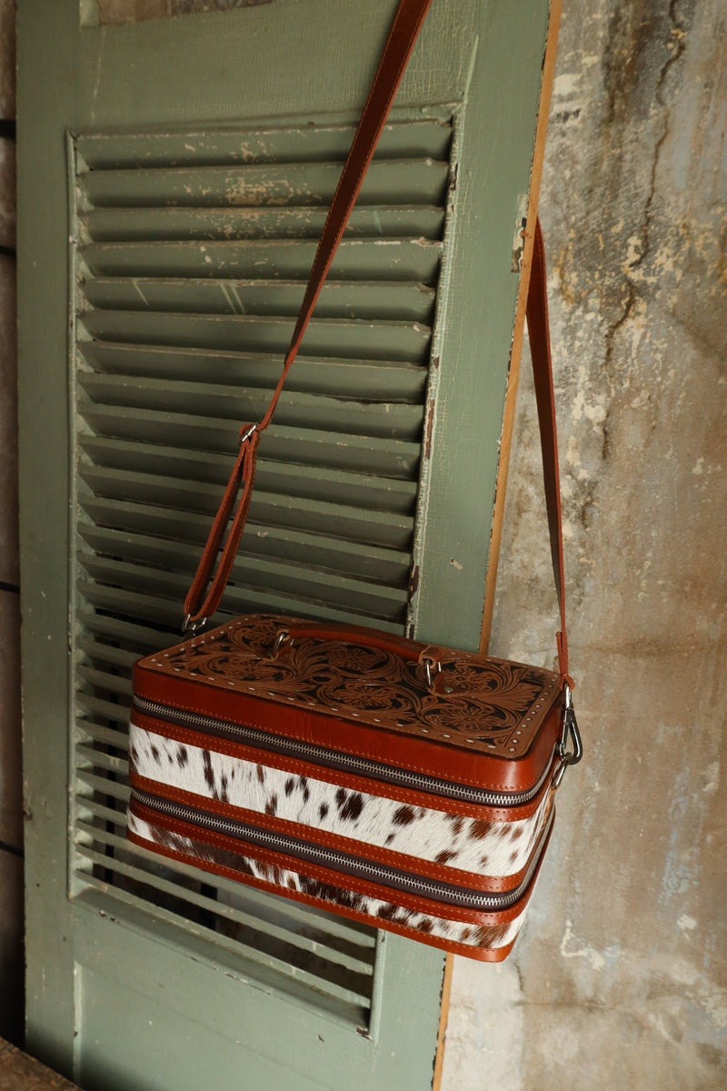 Double decker jewelry case with cowhide exterior and leather tooling and includes travel strap