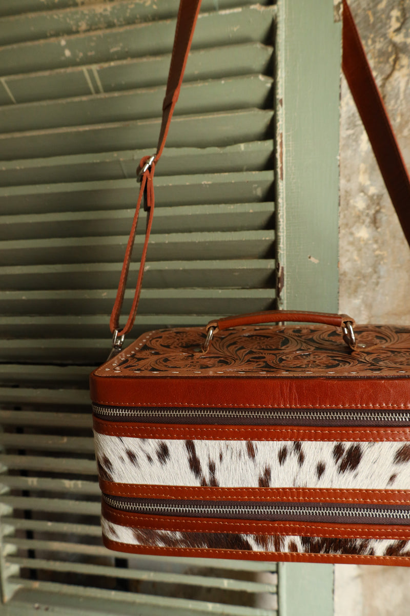 Double decker jewelry case with cowhide exterior and leather tooling and includes travel strap