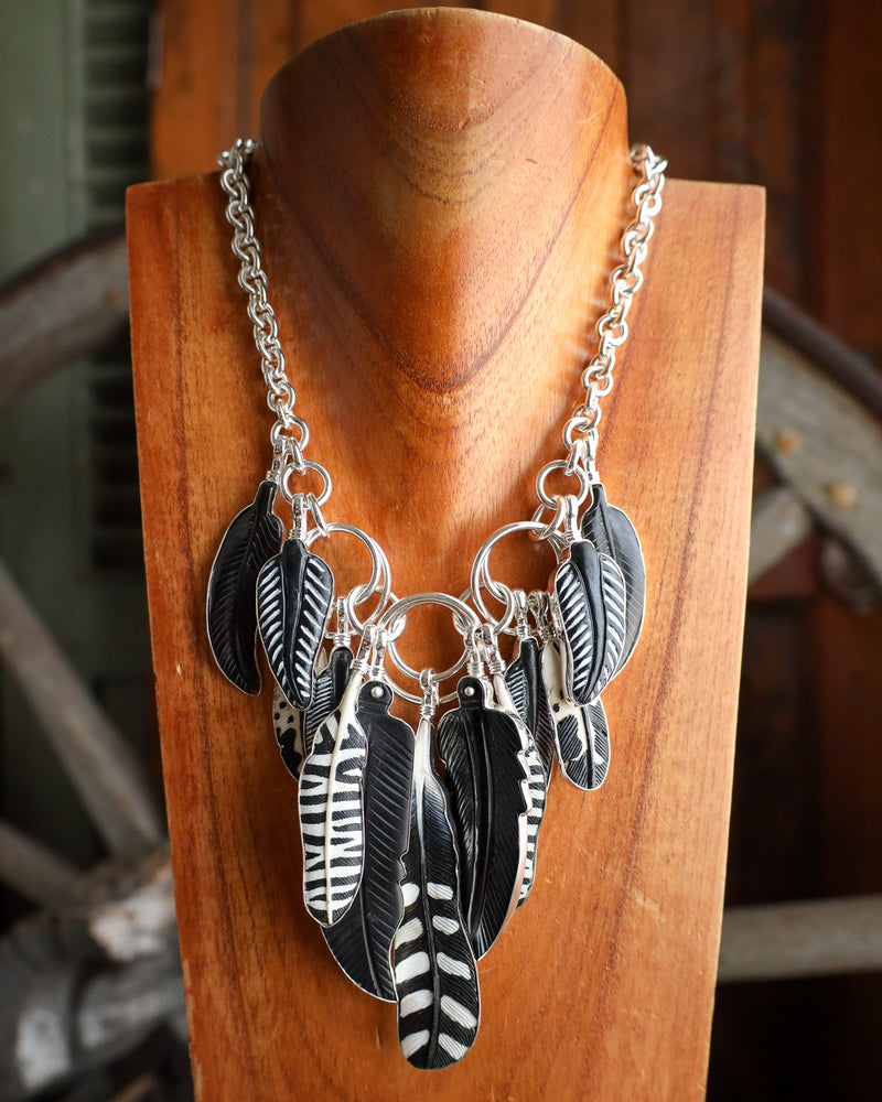 Necklace with feather-shaped pendants on a wooden stand