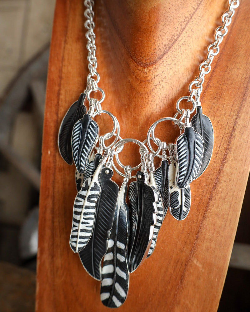 Necklace with feather pendants on a wooden surface