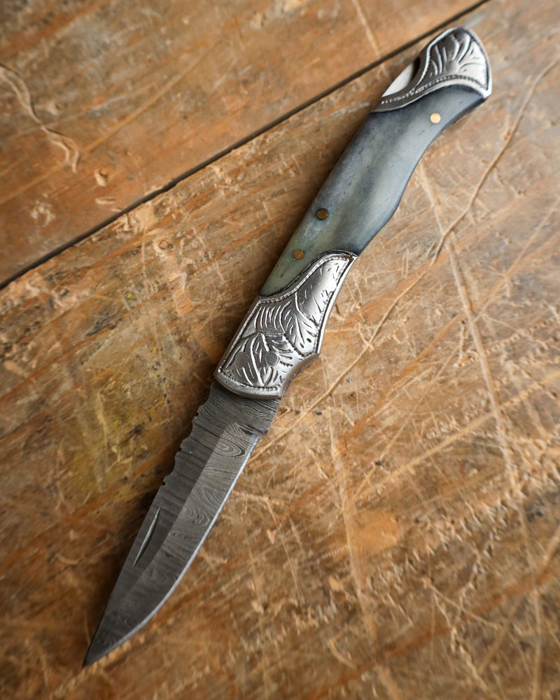 Forked knife with decorative handle on a wooden surface