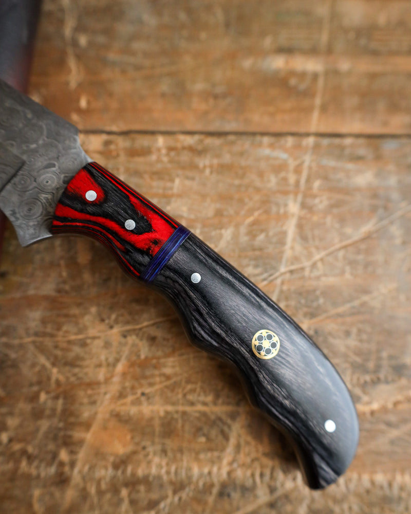 Knife with a red and black handle on a wooden surface