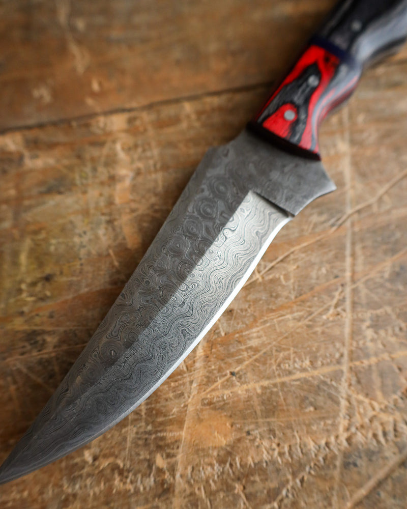 Knife with a decorative blade on a wooden surface