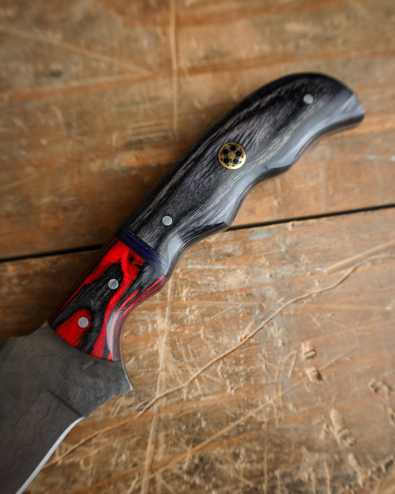 Knife with a black and red handle on a wooden surface