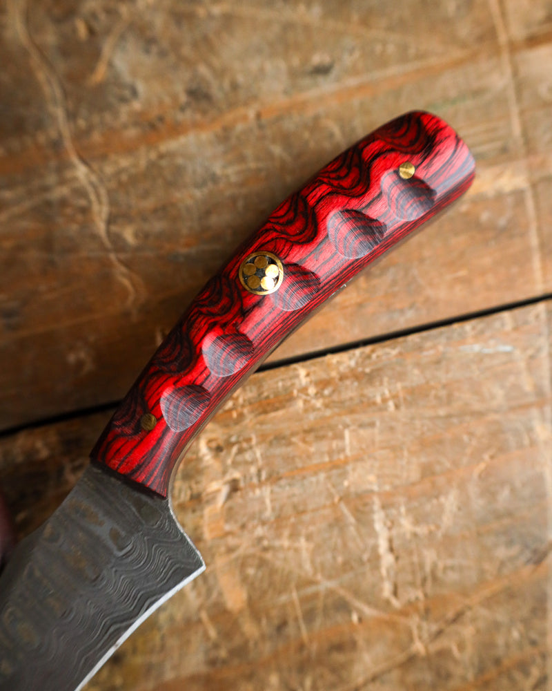 Knife with a red and black checkered handle on a wooden surface