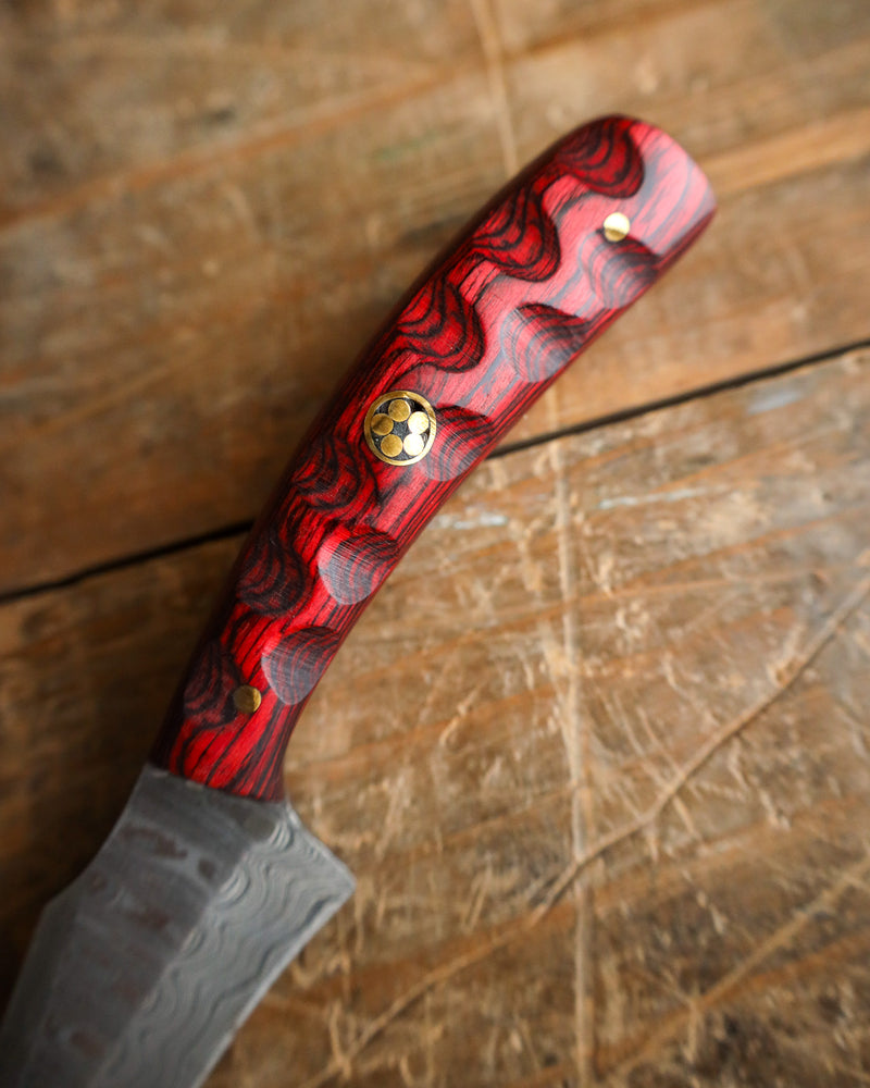 Knife with a red and black handle on a wooden surface