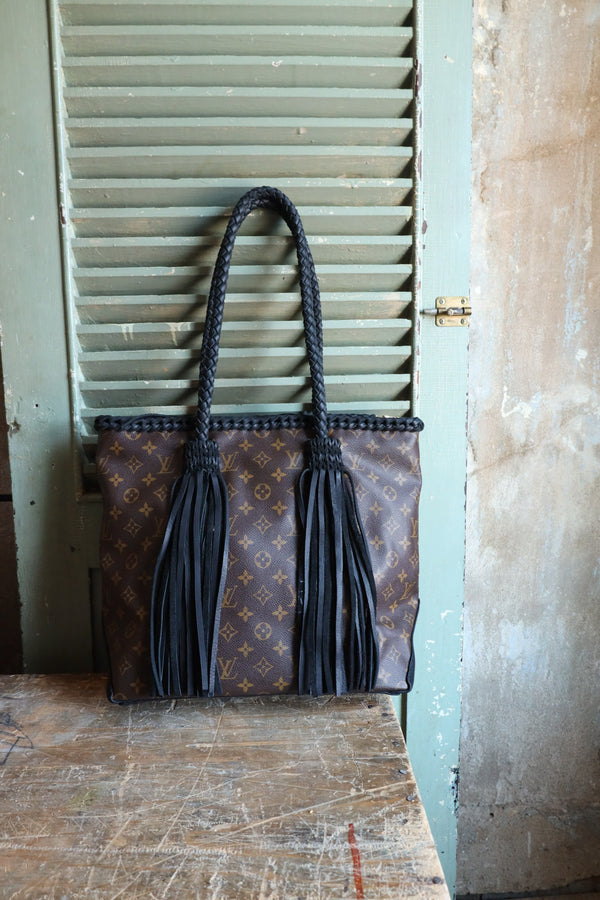  Cabas Mezzo Noir Handbag in the color Camel with Black Braided Bag with fringe embellishments. This bag also contains a zipper closure to secure all items placed inside.