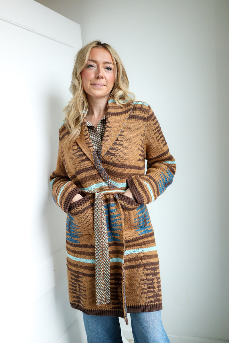 Woman wearing a patterned brown coat against a white background