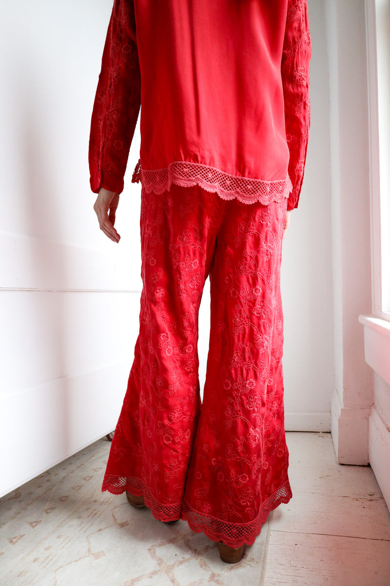 Person wearing a red lace outfit in a minimal indoor setting